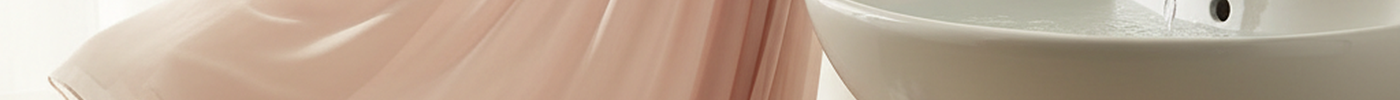 Helles Chiffonkleid am gepolsterten Buegel neben Waschbecken, Handtuch und Waeschenetz